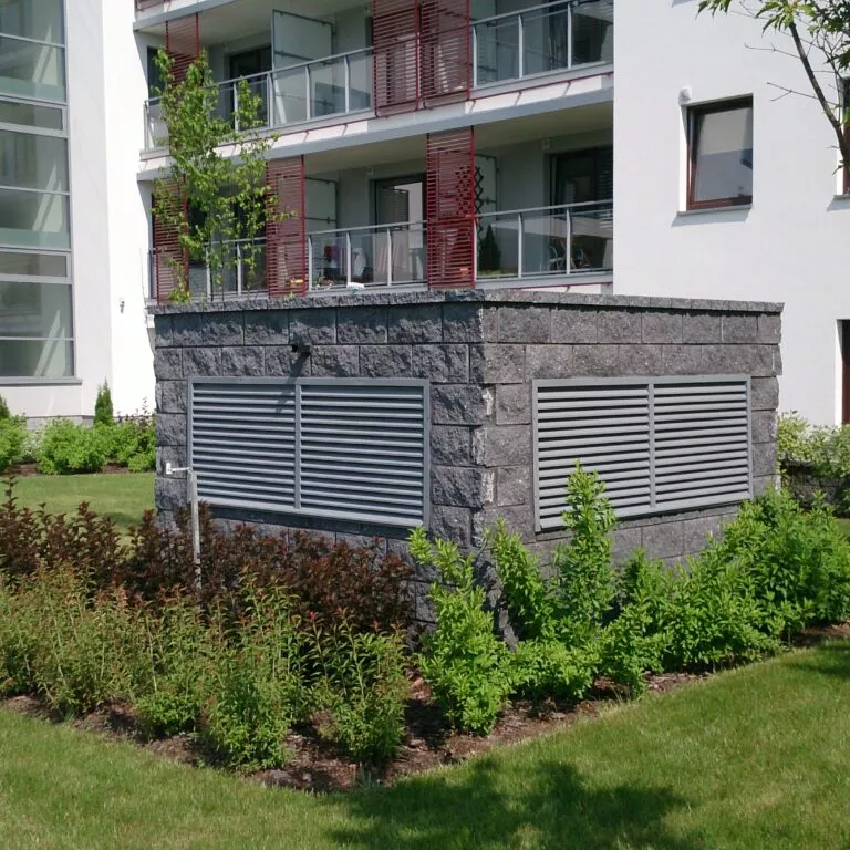 Szara krata wentylacyjna jednoczęściowa zamontowana na elewacji budynku mieszkalnego — realizacja Grid Poland