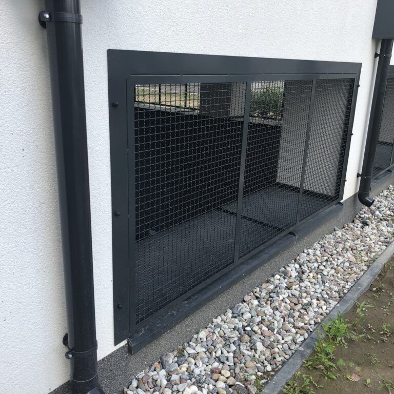 Czarna zabudowa siatkowa czerpni przy elewacji — realizacja Grid Poland