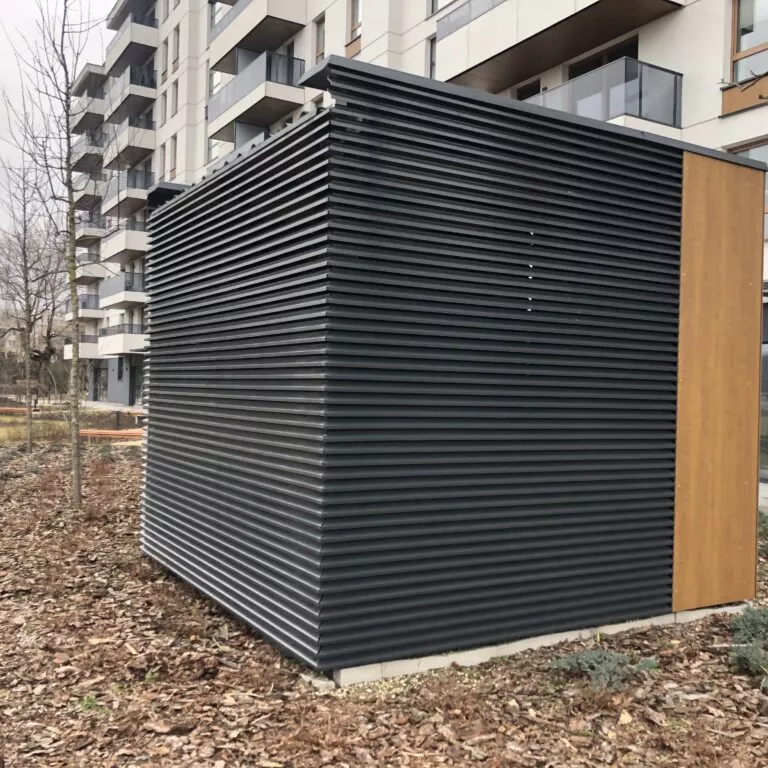 Grafitowa zabudowa lamelowa z czerpnią powietrza przy budynku mieszkalnym